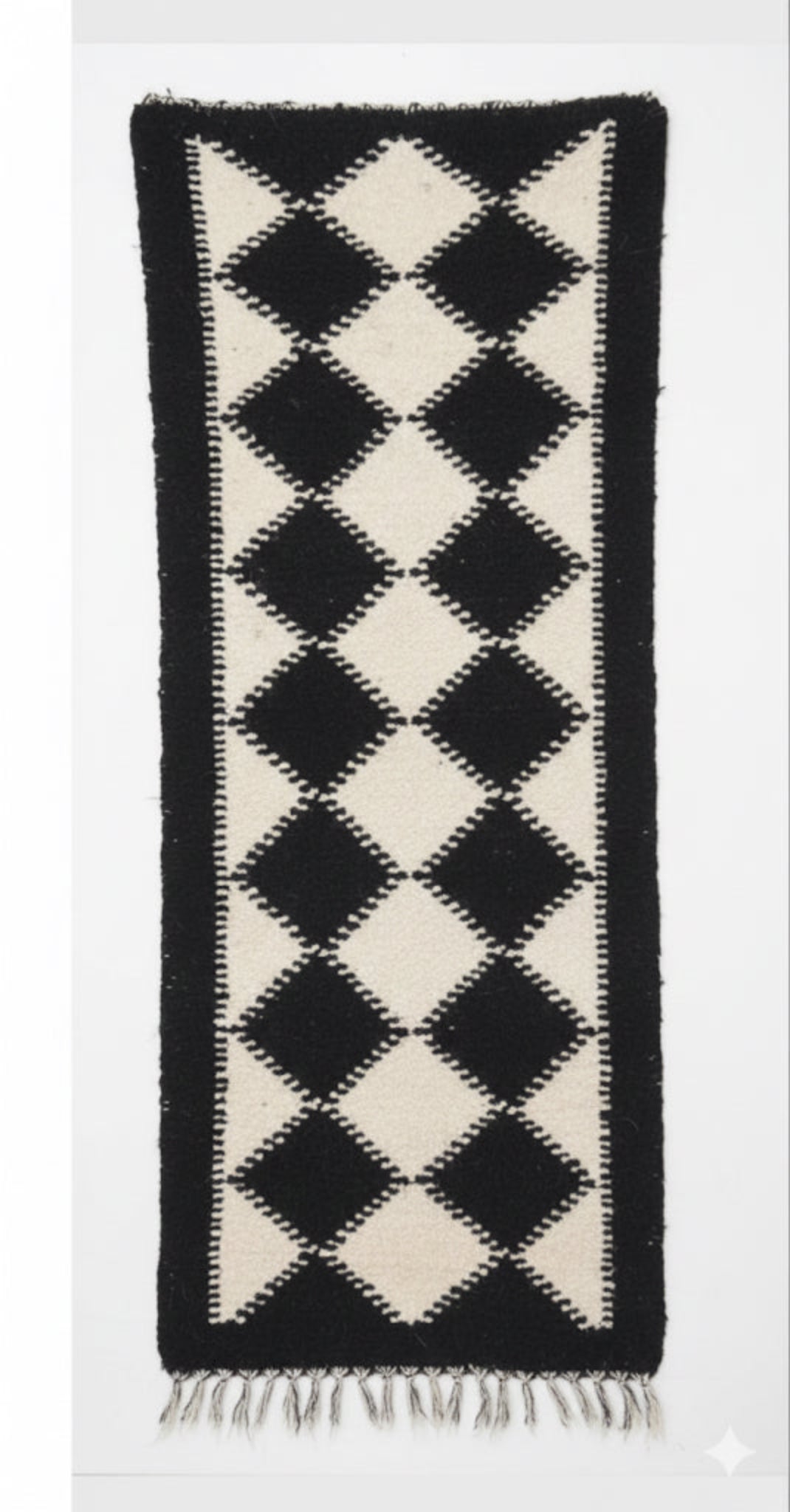 Black and white diamond patterned rug on a white background